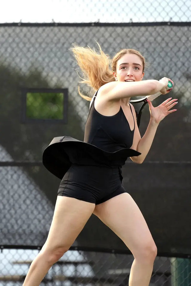 Must-have tennis gear shown in action with a player swinging her racket on court