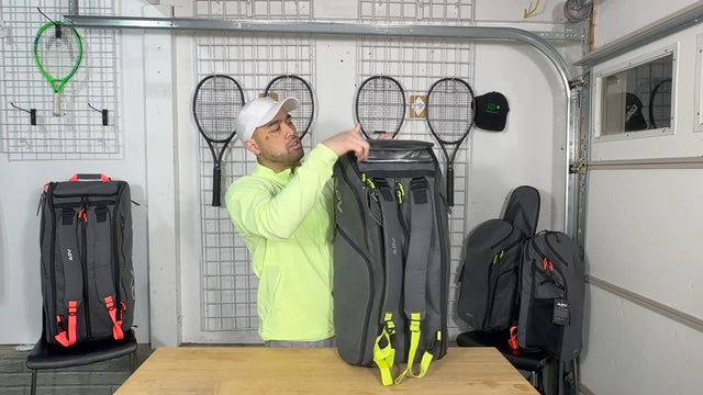 Tennis racket backpack with neon straps being reviewed by a man in a garage with tennis gear displayed.