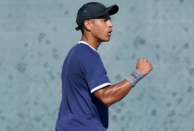 man holding his arm up with a tennis wristband in gray color on his right arm wrist