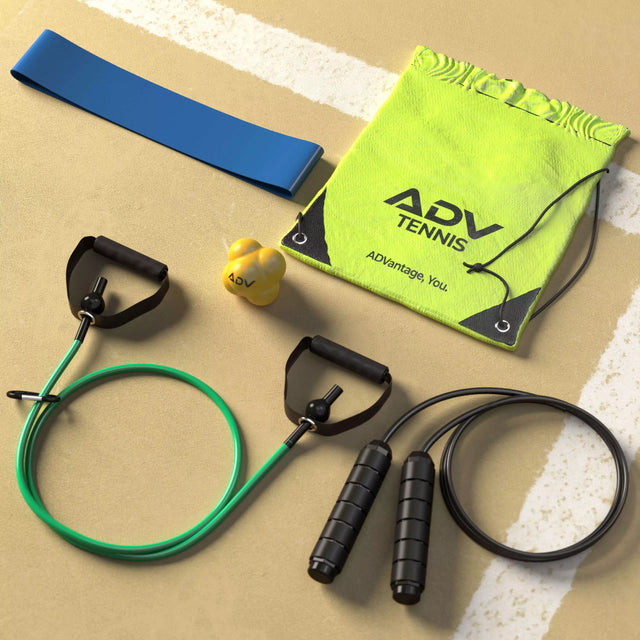 ADV Tennis fitness bag together with reaction ball, jump rope, strap and resistance band laying on tennis field